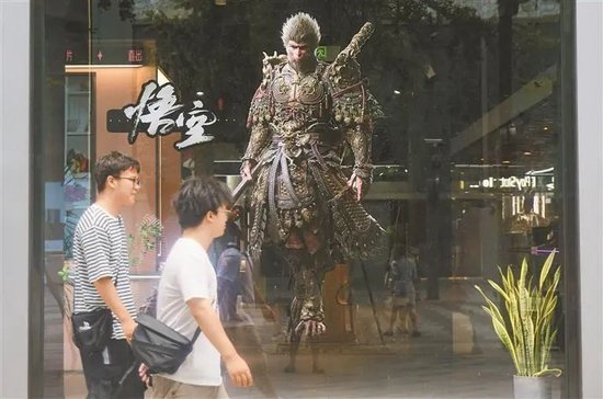 8月20日,游戏爱好者从游戏《黑神话:悟空》中悟空的形象海报前走过。新华社发