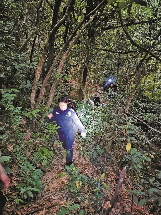天色渐暗,救援警力一边开着手电筒寻找一边向山林里行进。 盐田警方供图