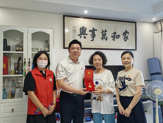 香蜜湖街道党工委副书记、办事处主任温现青同志,侨香社区党委书记尹靓同志为侨香社区老党员颁发“光荣在党50年”纪念章