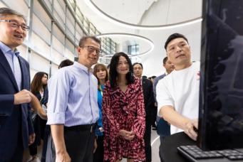 著名时装设计师vivienne tam与数码港初创公司ubivox创立人ivan fung向财政司司长陈茂波介绍如何透过3d扫描技术,化身成为数位模特儿,参与元宇宙时装表演。